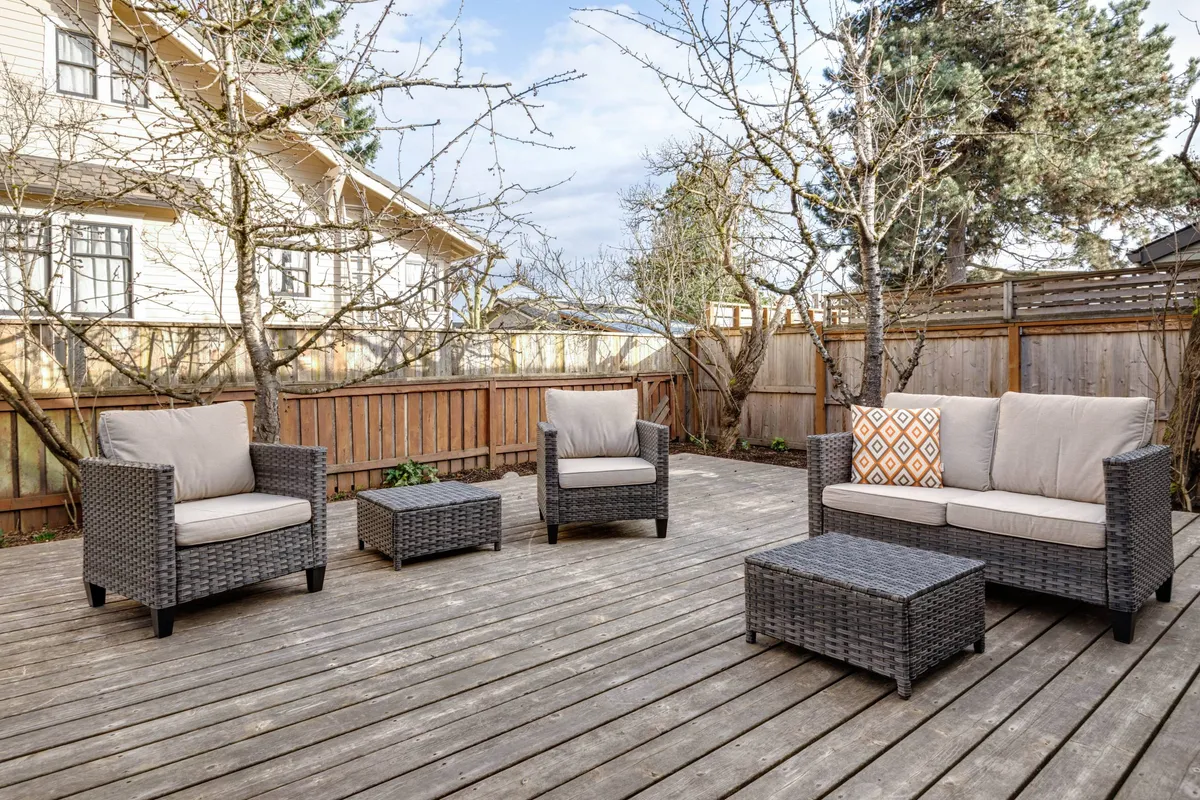 An inviting outdoor seating area featuring comfortable chairs, a coffee table, and decorative cushions. The setup is perfect for relaxing, socializing, or unwinding after a day at the nearby park or cultural center. The space feels private yet connected to the outdoors.