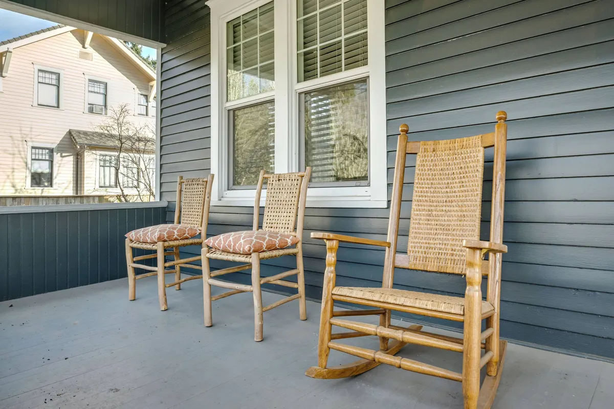 A welcoming porch with rocking chairs and large windows, bathed in warm light, inviting guests to relax after a day of tasting and dining adventures.